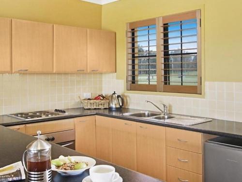 una cocina con fregadero y un plato de comida en una barra en Broken View Estate, en Pokolbin