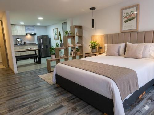 a bedroom with a large bed and a kitchen at Hotel 86 Suites in Bogotá