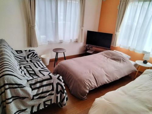 a bedroom with two beds and a tv in it at Winston in Chiba
