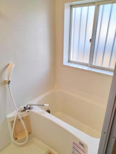 a bath tub in a bathroom with a window at Winston in Chiba