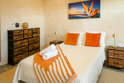 a bedroom with a bed with orange pillows at In Wotoch Chicxulub by Casago in Chicxulub