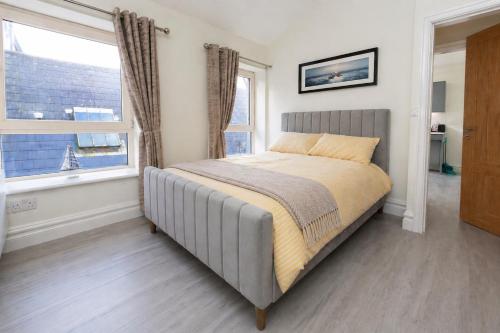 a bed in a bedroom with a large window at Unit 3 Modern Self Contained Apartment in Cobh