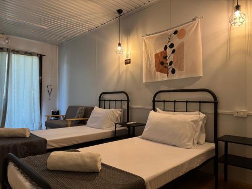 a hotel room with two beds and a couch at Siqui Pods in Siquijor