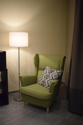 a green chair with a pillow in a room at Cento Tari' Guest House in Castiglione di Sicilia