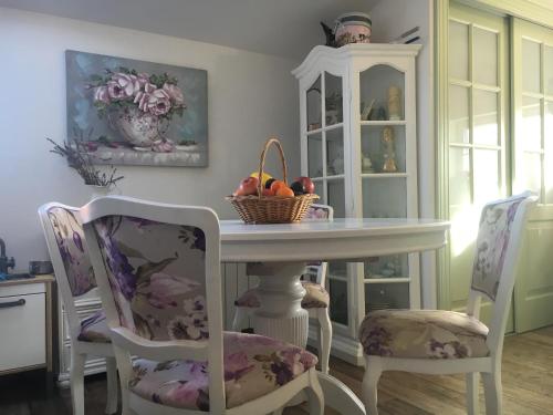 a table with a basket of fruit and two chairs at House Anastazia Pool & Panoramic Sea View in Lovran