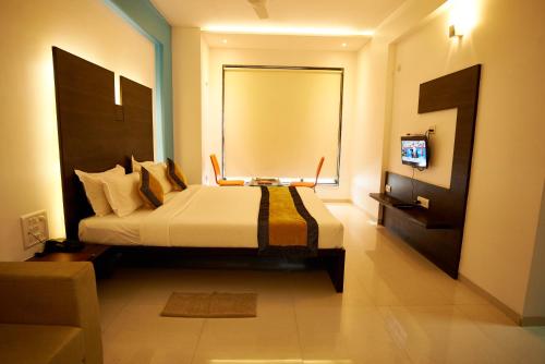 a bedroom with a bed with a television in it at Hotel Golden View in Shirdi