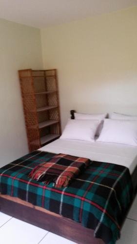 a bedroom with a bed with a plaid blanket on it at Casas na Praia de Bombas - Bombinhas in Bombinhas