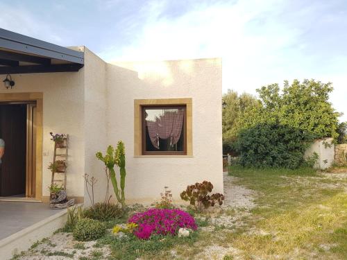 Una casa con una ventana y flores en un patio. en Villa Agape, en Marina di Noto