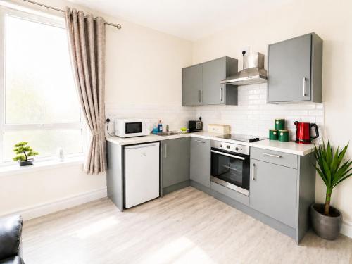 a kitchen with stainless steel appliances and a window at Unit 1 Island View Apartments - Town Centre Walk To Everything in Cobh