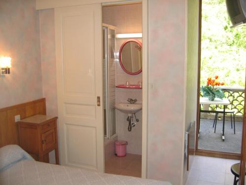 y baño con lavabo y espejo. en Chambres d'Hôtes Le Terminus, en Fontan
