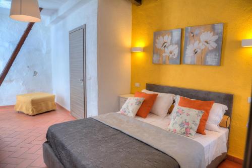 a bedroom with a bed with orange and white pillows at La Casa di Pietra in Villa Faraldi