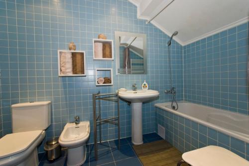 a blue tiled bathroom with a toilet and a sink at Apartments in downtown in Lisbon