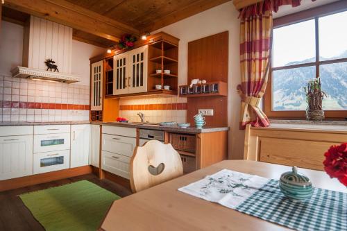a kitchen with wooden cabinets and a table and a window at Chalet Schröckgut in Bad Hofgastein