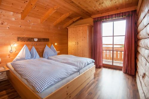 Bett in einem Holzzimmer mit Fenster in der Unterkunft Chalet Schröckgut in Bad Hofgastein