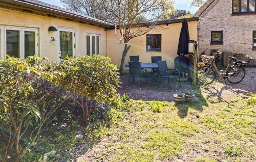 a backyard with a table and chairs and an umbrella at Nice Home In Samsø With Wifi in Ballen