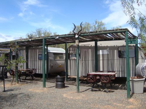 an rv and a picnic table under a shed at Natures Rest Lapa in Oudtshoorn