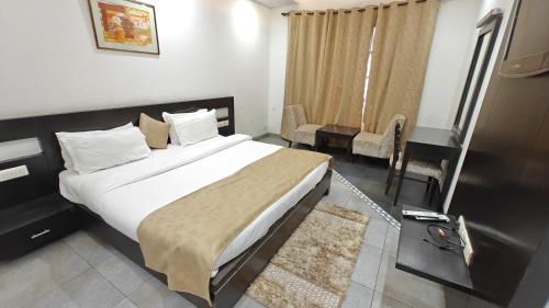 a bedroom with a large bed and a table and chairs at Hotel Raunak in Pinjaur
