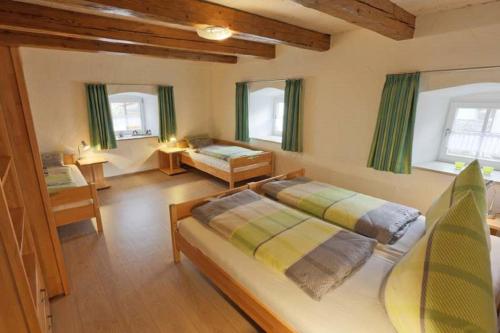 1 dormitorio grande con 2 camas y 2 ventanas en Ferienhaus Wimbauer, en Nennslingen
