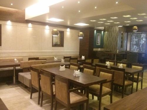 a dining room with tables and chairs in a restaurant at Hotel Le Grande - Mumbai International Airport in Mumbai