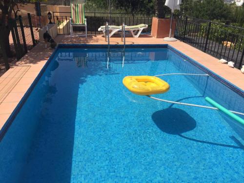 una piscina con un frisbee amarillo en el agua en Casa Llorens, en Denia