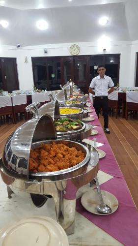 a buffet line with plates of food on a table at Jungle Safari Resort in Sauraha