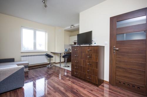 a living room with a large wooden door and a desk at Apartamenty w Klaudynie in Klaudyn