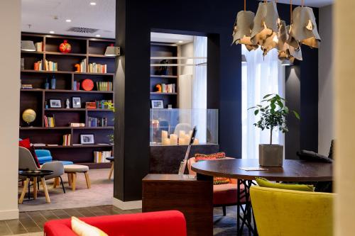 a room with a table and chairs and a book shelf at Mercure Hotel & Residenz Berlin Checkpoint Charlie in Berlin