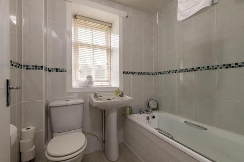 a bathroom with a toilet and a sink and a tub at Bangor Cottage - Elie in Elie