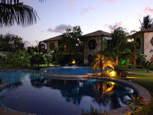 una piscina frente a una casa por la noche en Pousada Morada dos Ventos, en Pipa