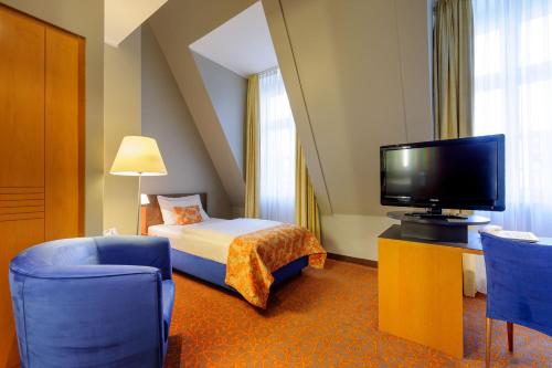 a hotel room with a bed and a television at Mercure Hotel & Residenz Berlin Checkpoint Charlie in Berlin
