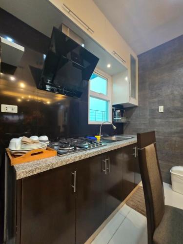 a kitchen with a stove and a sink at J Spazio Apartelle and Cafe in Baranghauon