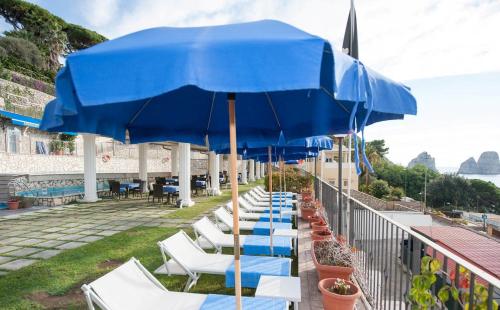 a row of chairs and umbrellas on a balcony at Hotel Weber Ambassador in Capri
