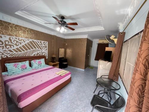a bedroom with a bed and a ceiling fan at SouanSonBeachResort in Klaeng