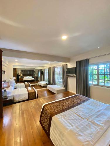 a bedroom with two beds and a living room at Commander Suites de Velada in Antipolo