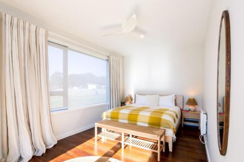 a bedroom with a bed and a large window at Toi Toi Apartment in Martinborough