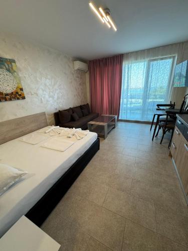 a hotel room with a bed and a couch at Lozenetz Beach Apartments in Lozenets
