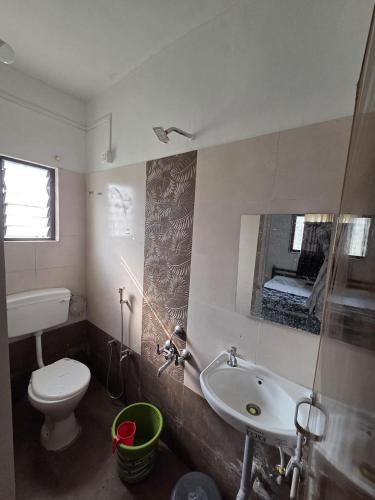 a bathroom with a toilet and a sink and a tub at Hotel Sur Sangam in Nashik