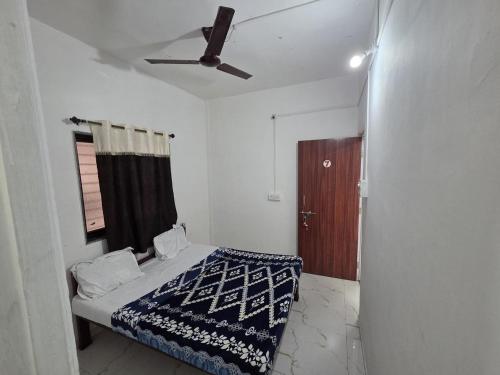 a bedroom with a bed and a ceiling fan at Hotel Sur Sangam in Nashik