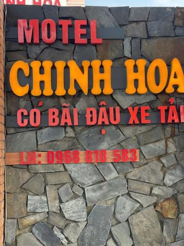 a sign on the side of a stone wall at Hotels Motel Nhà nghỉ CHINH HOA PLASS in Ấp Ray