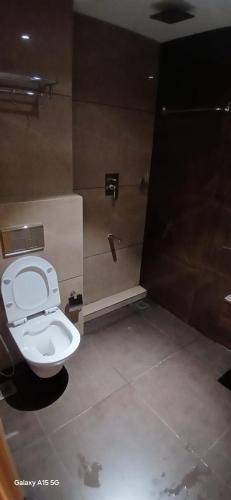a bathroom with a toilet and a shower at Florys Residency in Ooty