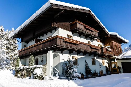 a house with a snow covered roof on top of it at Ferienhaus Hohenwarter in Lofer