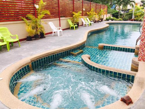 a swimming pool with chairs and chairs in a resort at Mei Zhou Phuket Hotel - SHA Plus in Phuket