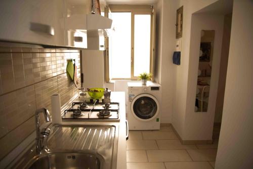 una cucina con piano cottura e lavatrice di Carol House a Napoli