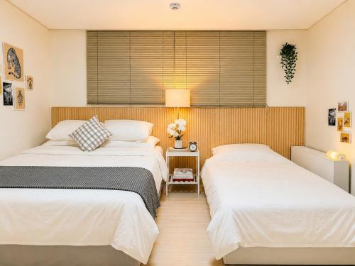 a bedroom with two beds and a window at Hongdae 10 min Family 2BR Direct Airport Bus from ICN airport in Seoul