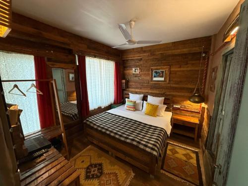 a bedroom with a bed in a room with wooden walls at MeenaBagh Villa Rooms & Cafe in Shimla