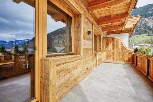a wooden house with a balcony with mountains at Hotel Giessenbach in Fügen
