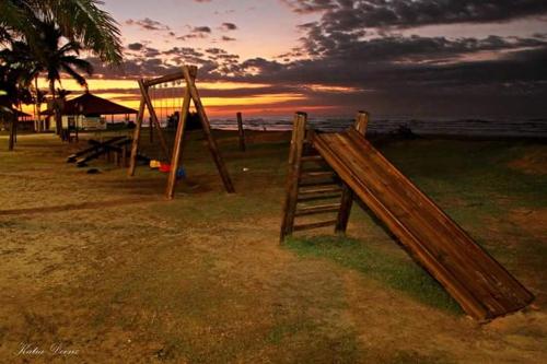 a wooden playground with a slide on the beach at Hostel Itanhaém in Itanhaém