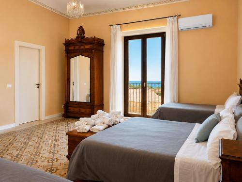 a bedroom with two beds and a large window at Alloggio della Posta Vecchia in Agrigento
