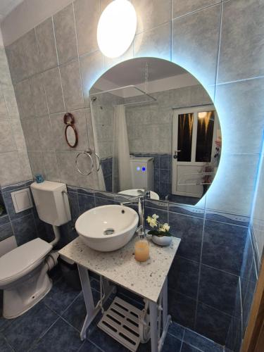 a bathroom with a sink and a toilet and a mirror at Ava Studio in Cisnădie