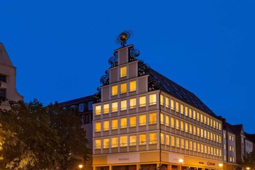 a building with a clock tower on top of it at Vienna House by Wyndham Sonne Rostock in Rostock